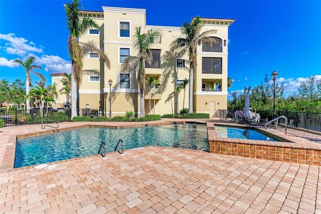 view of swimming pool with a hot tub