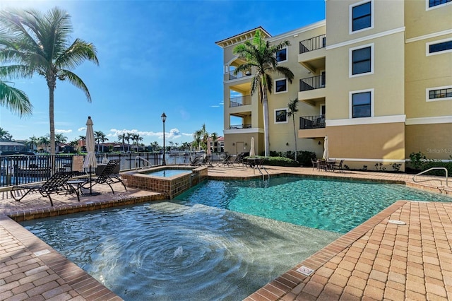 view of pool with a community hot tub and a patio area