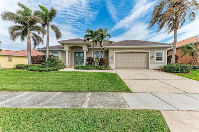 view of front of house featuring french doors, a garage, and a front lawn