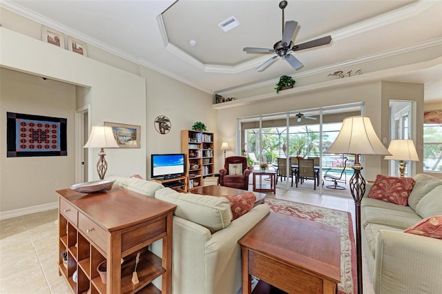 tiled living room featuring a raised ceiling, ceiling fan, and ornamental molding