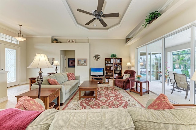 living room with a raised ceiling, a wealth of natural light, ceiling fan, and crown molding