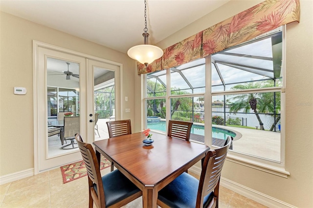 tiled dining space featuring ceiling fan, french doors, and a healthy amount of sunlight