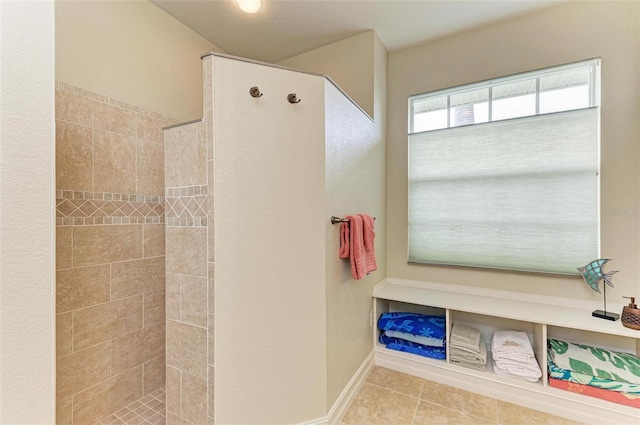 bathroom with tile patterned flooring and a tile shower