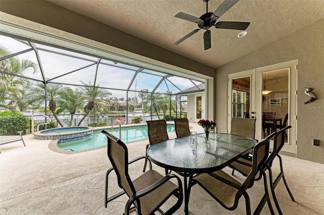 view of pool with a lanai, an in ground hot tub, ceiling fan, and a patio