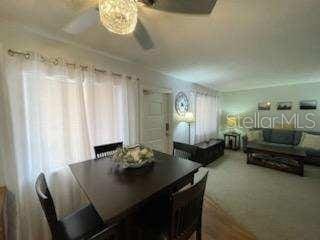 carpeted dining space featuring ceiling fan