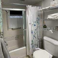 bathroom featuring shower / bath combo with shower curtain and toilet