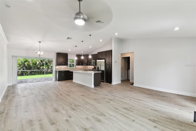 kitchen featuring appliances with stainless steel finishes, a center island, light hardwood / wood-style flooring, and hanging light fixtures