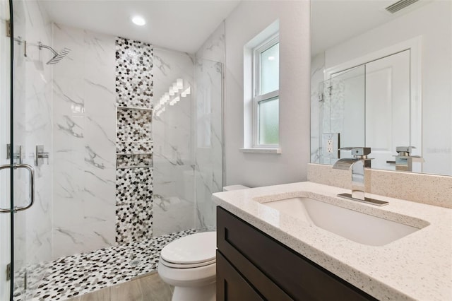 bathroom with wood-type flooring, vanity, toilet, and an enclosed shower