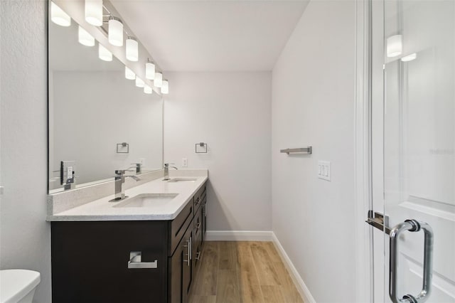 bathroom with hardwood / wood-style floors, vanity, and toilet