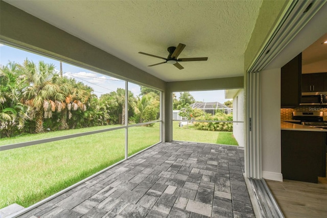 unfurnished sunroom with ceiling fan