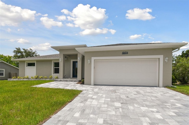 18854 Ackerman Ave, Port Charlotte, FL 33948 - view of front of property with stucco siding, a front lawn, decorative driveway, and an attached garage