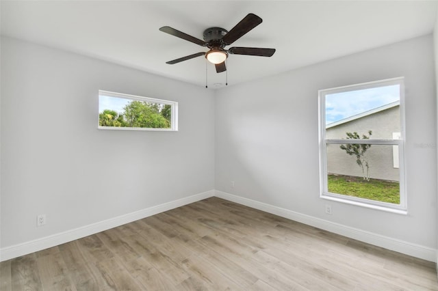 spare room featuring ceiling fan, a healthy amount of sunlight, and light wood-type flooring