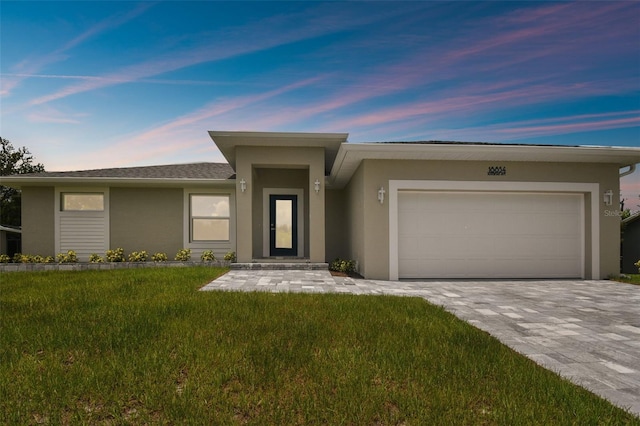 18854 Ackerman Ave, Port Charlotte, FL 33948 - prairie-style house featuring stucco siding, an attached garage, a yard, and decorative driveway