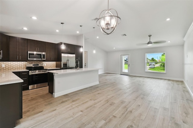 kitchen with hanging light fixtures, light hardwood / wood-style flooring, lofted ceiling, ceiling fan with notable chandelier, and appliances with stainless steel finishes