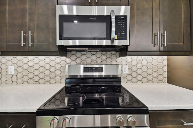 kitchen featuring dark brown cabinets, decorative backsplash, light stone countertops, and appliances with stainless steel finishes