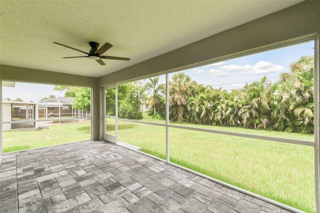 unfurnished sunroom with ceiling fan