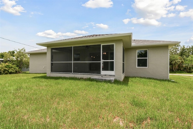 back of property with a yard and a sunroom