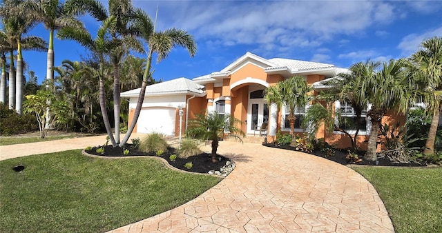 mediterranean / spanish-style house with a front yard and a garage