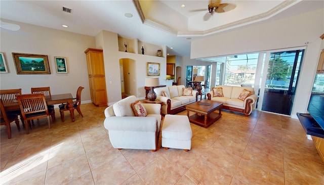 living room with a raised ceiling and ceiling fan