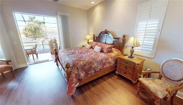 bedroom with hardwood / wood-style floors and access to outside