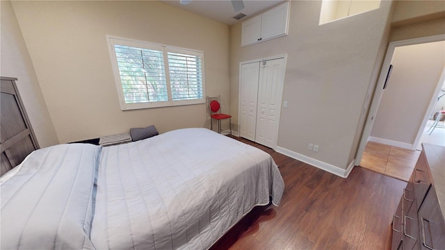 bedroom with dark hardwood / wood-style floors, ceiling fan, and a closet