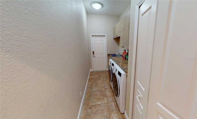 laundry room with washing machine and dryer, sink, light tile patterned floors, and cabinets