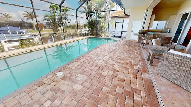 view of swimming pool with a lanai, a grill, sink, and a patio