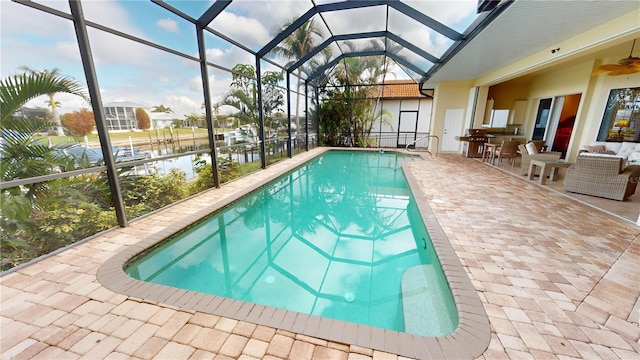 view of pool featuring a lanai, a patio area, and a water view