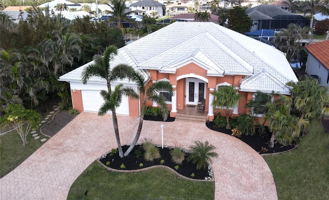 view of front of property with a front lawn, a garage, and french doors