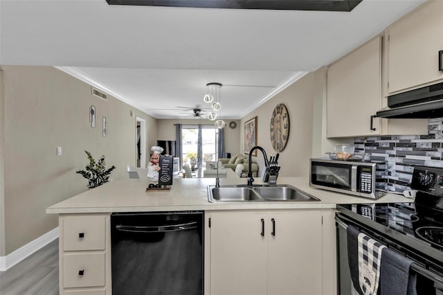 kitchen with ceiling fan, sink, backsplash, black appliances, and ornamental molding