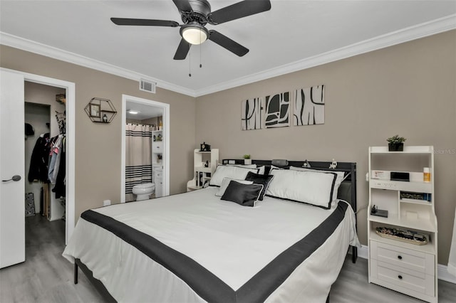 bedroom featuring ensuite bathroom, crown molding, ceiling fan, light wood-type flooring, and a closet