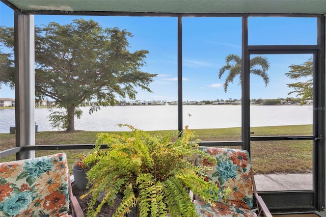 unfurnished sunroom featuring a water view