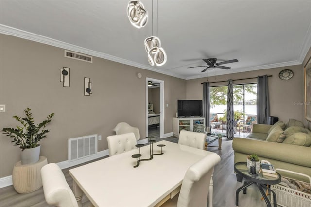 dining space featuring ceiling fan, crown molding, and light hardwood / wood-style flooring