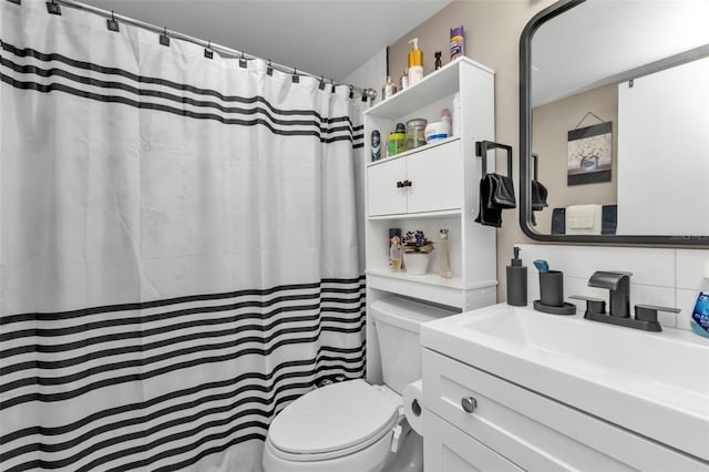 bathroom with vanity, curtained shower, backsplash, and toilet