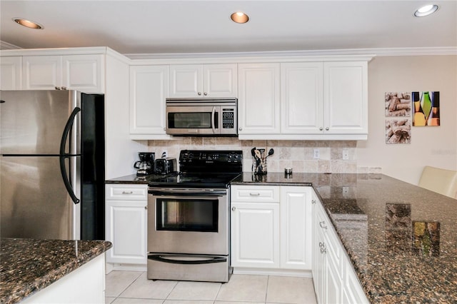 kitchen with white cabinets, decorative backsplash, dark stone countertops, and appliances with stainless steel finishes