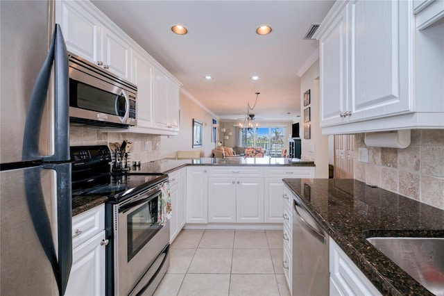 kitchen featuring white cabinets, crown molding, stainless steel appliances, and tasteful backsplash