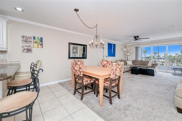 dining space featuring light tile patterned flooring, ceiling fan with notable chandelier, and ornamental molding