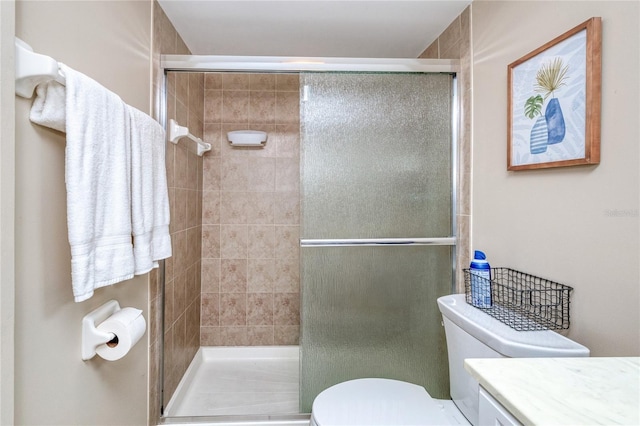 bathroom with vanity, toilet, and a shower with door