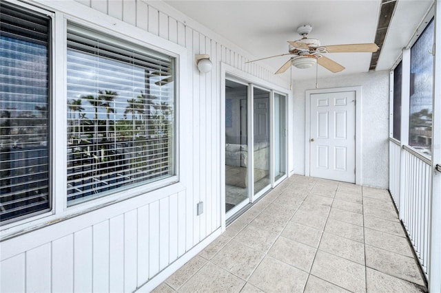 unfurnished sunroom with ceiling fan