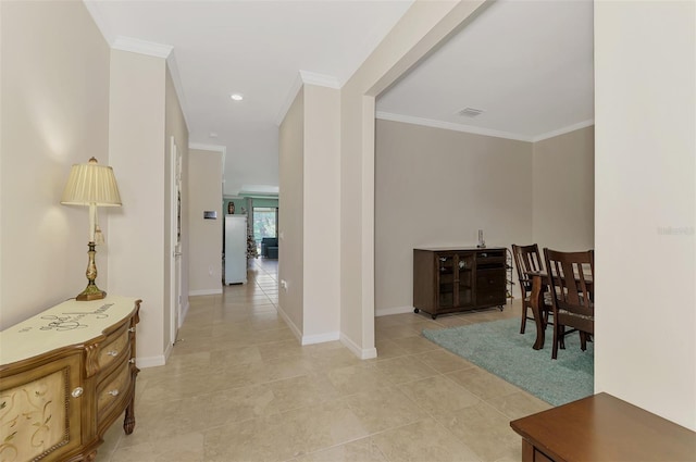 corridor featuring light tile patterned floors and crown molding