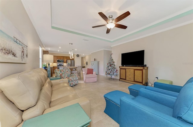 living room with ceiling fan, light tile patterned floors, crown molding, and a tray ceiling