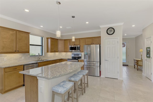 kitchen featuring light stone countertops, a center island, sink, stainless steel appliances, and ornamental molding