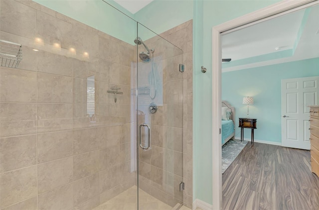 bathroom featuring a tray ceiling and an enclosed shower