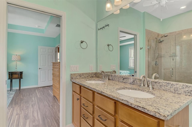 bathroom featuring hardwood / wood-style flooring, ceiling fan, walk in shower, and vanity