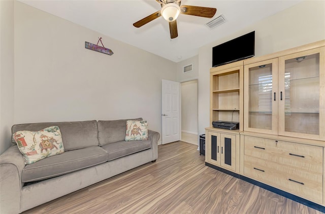 living room featuring wood-type flooring and ceiling fan