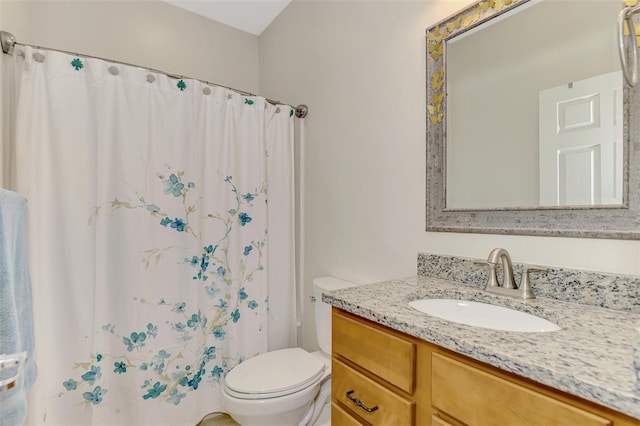 bathroom featuring curtained shower, vanity, and toilet