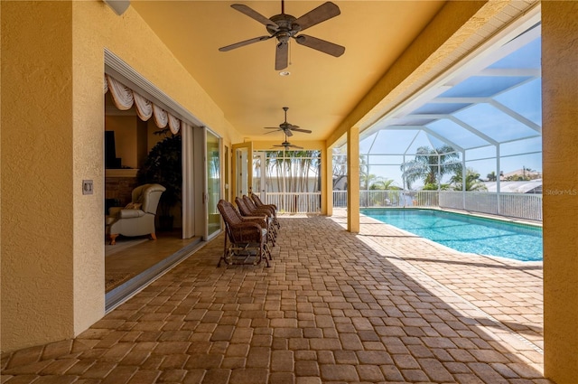 view of pool with a patio, ceiling fan, and glass enclosure