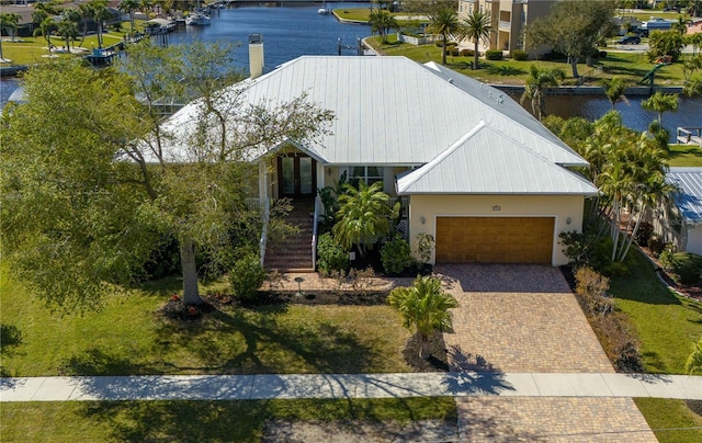 view of front of home with a garage and a water view