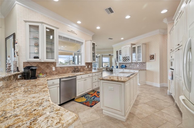 4431 Gardner Dr, Port Charlotte, FL 33952 - kitchen featuring white appliances, ornamental molding, backsplash, light stone counters, and a kitchen island