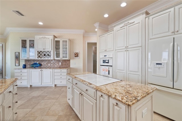 4431 Gardner Dr, Port Charlotte, FL 33952 - kitchen with white appliances, ornamental molding, glass insert cabinets, light stone countertops, and a center island